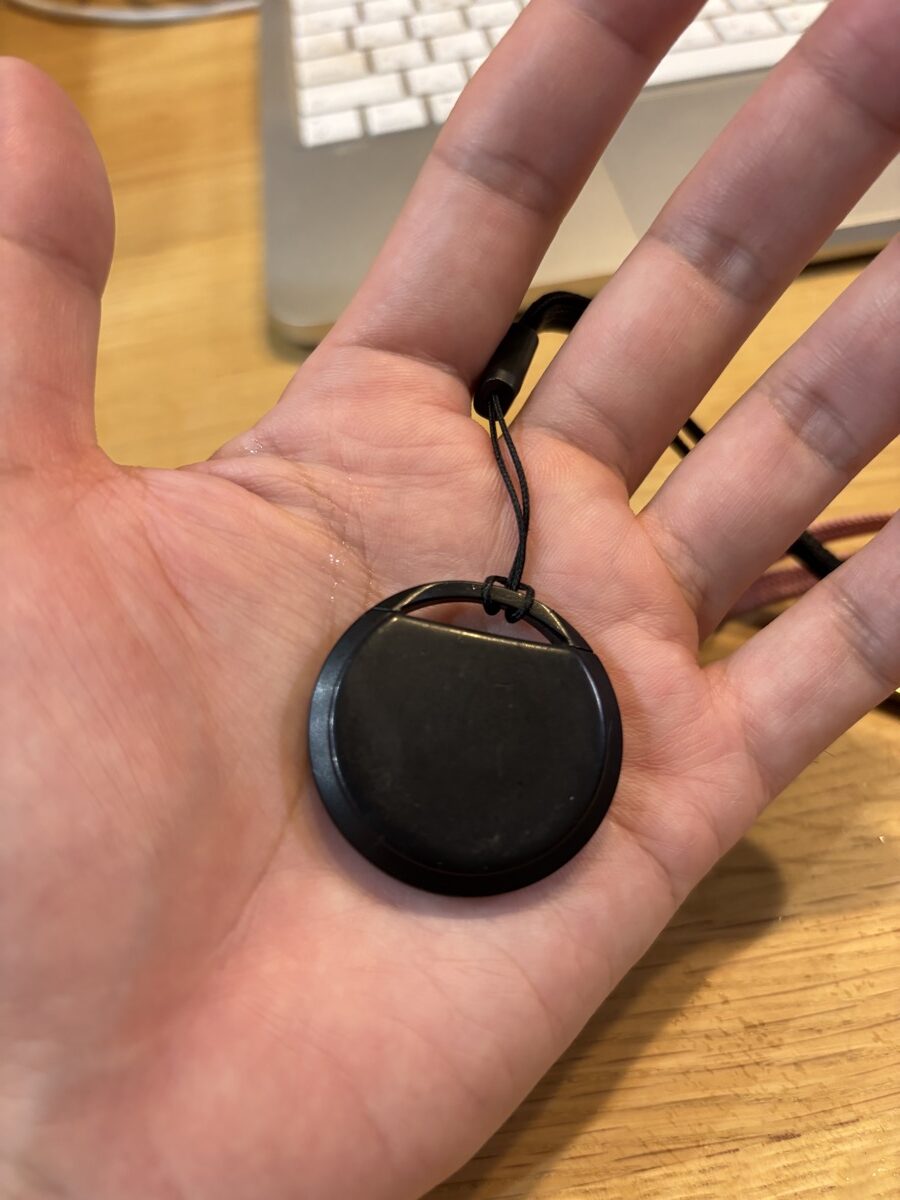 サードパーティ製AirTag(黒)を手のひらにのせて大きさを比較